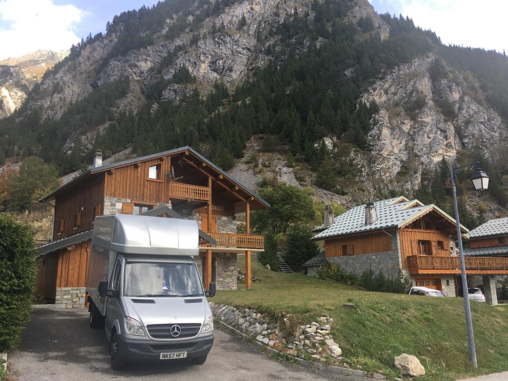 A Yorkshire Van Man vehicle parked outside a Challet with a mountain in the background