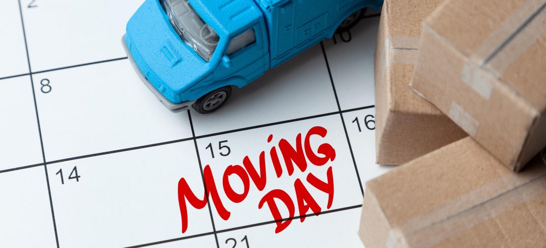 Moving day on the calendar is written in red. Calendar with a note with cardboard boxes and truck.